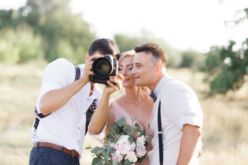 Wedding,Photographer,Takes,Pictures,Of,Bride,And,Groom,In,Nature.